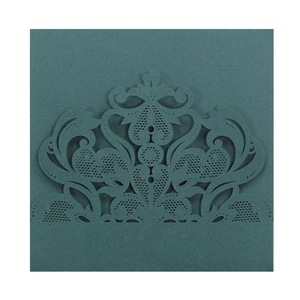 Intricate laser-cut floral pattern on a dark teal wedding invitation sleeve cover