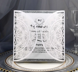 Elegante Laserschnitt-Hochzeitseinladung mit silbernem Glitzerrand und weißem Blumenmuster