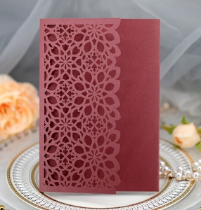 Detailed laser-cut floral pattern on a burgundy pearl paper wedding invitation cover