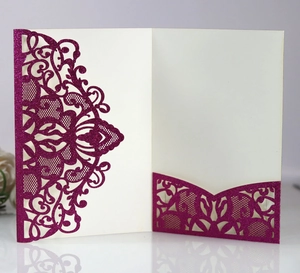 Macro detail of laser-cut lace pattern on rose red glitter engagement invitation
