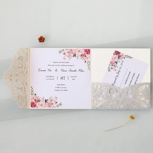Detail of laser-cut lace wedding invitation with gold glitter and floral RSVP cards