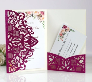 Detail of laser-cut glittery burgundy wedding invitation with intricate floral lace patterns