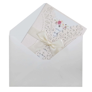 Detail of laser-cut rose invitation with pearl paper cover and pink floral inner card