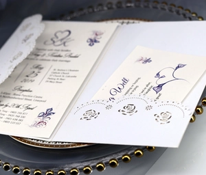Détail de l'invitation de mariage découpée au laser avec roses sur papier perlé blanc