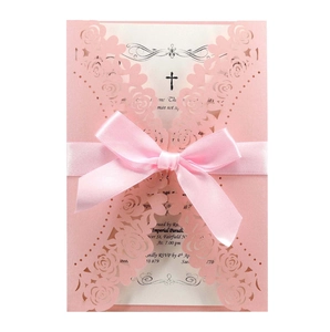Pink laser-cut floral invitation card with religious cross and elegant satin ribbon bow
