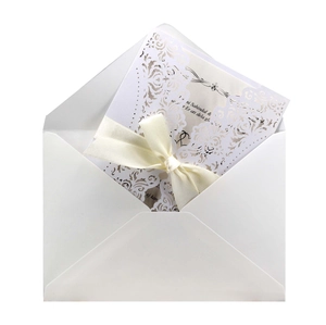 Elegant white laser-cut wedding invitation with satin bow and floral pattern