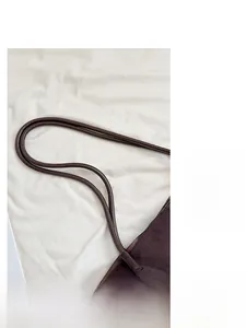 Détail du cabas en daim marron foncé avec fines anses cylindriques et coutures renforcées