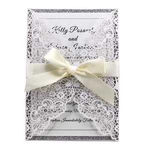 Elegant laser-cut lace wedding invitation with silver glitter edge and cream satin ribbon