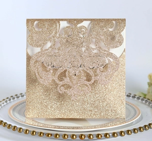 Detail of rose gold laser-cut wedding invitation with glitter floral hollow design
