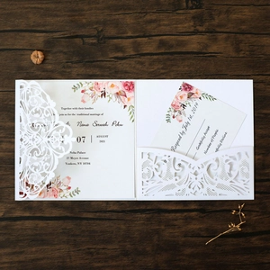 Detailed laser cut lace wedding invitation with floral watercolor inner card on wood