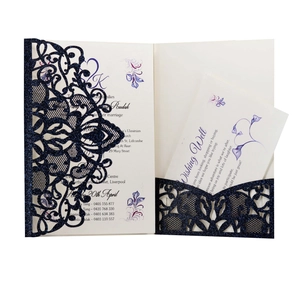 Close-up of navy blue glitter laser cut wedding invitation with delicate lace pattern