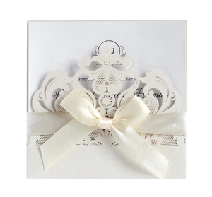 Detailed laser-cut hollow lace wedding invitation with ivory envelope and silk ribbon bow