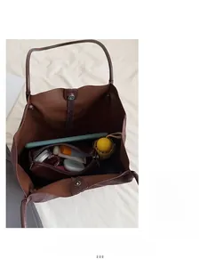 Grand sac fourre-tout marron foncé montrant l'espace intérieur et une pochette assortie