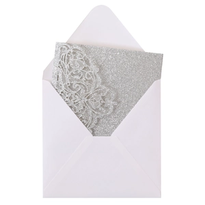 Detailed macro view of laser-cut floral lace texture on a silver glitter invitation card