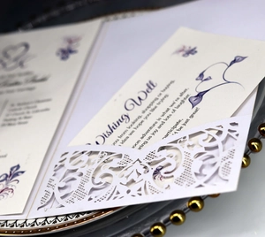 Dettaglio del set di inviti di nozze tagliati al laser con carte floreali sulla tavola