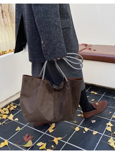 Détail du grand sac cabas en daim marron avec anses grises et design trapèze spacieux