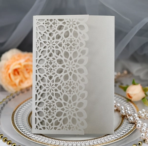 Detailed laser-cut floral wedding invitation on pearlescent paper with luxury decor