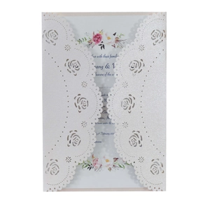 Detail of laser-cut rose floral wedding invitation with intricate lace hollow edges