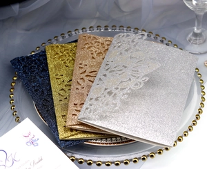 Macro detail of laser-cut lace wedding invitations with glitter finish in four colors