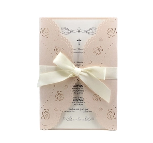 Close-up of laser-cut rose patterns on elegant pink pearlescent paper invitation card