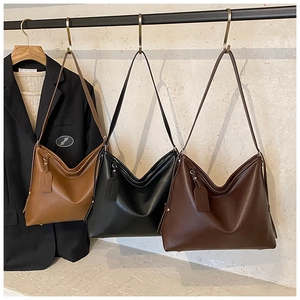 Detailed display of three large hobo tote bags in brown, black, and coffee for commuting