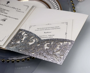 Detail of silver glitter laser-cut lace wedding invitation pocket with intricate swirls