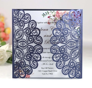 Detail of laser-cut navy blue wedding invitation with intricate mandala floral patterns