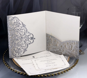 Macro detail of laser-cut glitter silver wedding invitation with elegant hollow patterns