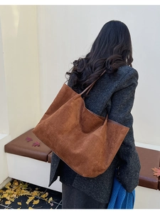 Grand sac cabas en daim marron caramel porté à l'épaule pour les trajets d'automne