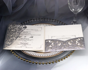 Detailed laser-cut silver glitter wedding invitation set with elegant lace patterns