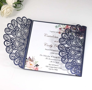 Detailed laser-cut navy blue wedding invitation with floral insert and intricate lace design