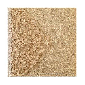 Close-up of laser-cut glitter gold wedding invitation with intricate lace pattern detail