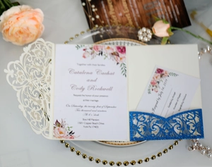 Detail view of laser-cut wedding invitation with glitter insert and floral design