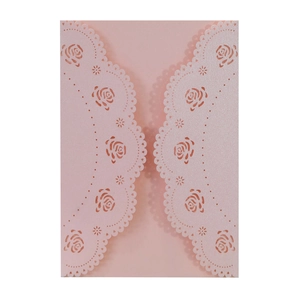 Macro shot of laser-cut rose hollow pattern on pink pearlescent paper invitation card