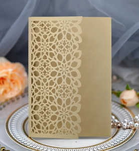 Detail of laser-cut floral invitation cover in champagne gold with pearlescent texture