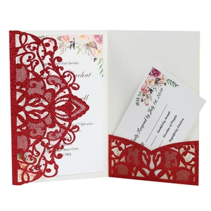 Laser cut red glitter wedding invitation card set with floral inserts on white background