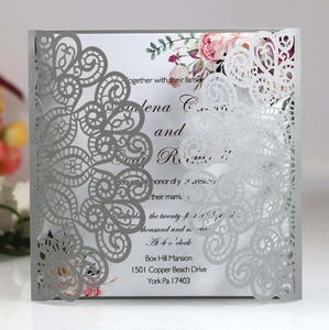 Detail of laser-cut silver glitter wedding invitation with floral lace and rose inner card