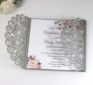 Macro view of silver laser-cut lace invitation card with elegant floral details