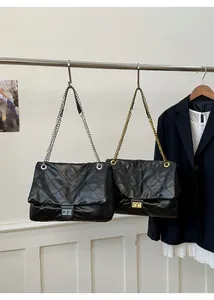 Close-up of quilted chain tote bags featuring gold and silver metal turn-lock buckles