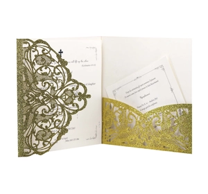 Detail of laser-cut gold glitter wedding invitation with intricate lace vine patterns