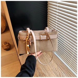 Détail du sac à main vintage kaki avec boucle dorée et pendentif en perles de bois ethniques