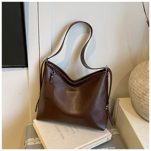 Detailed view of matte dark coffee leather texture and silver hardware on hobo shoulder bag