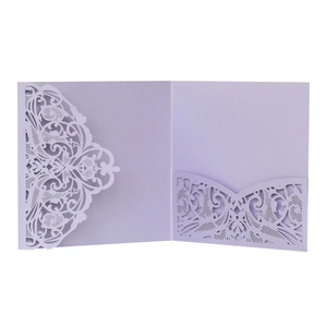 Macro detail of laser-cut lace patterns on a pearlescent lavender invitation card