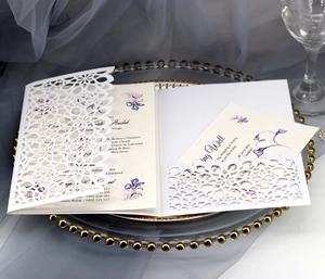 Macro view of white laser-cut wedding invitation with elegant floral inner card details