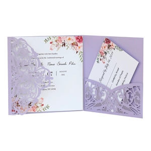 Detail of laser-cut lace pattern on purple wedding invitation with floral card insert