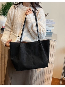 Détails du sac cabas en daim noir avec fines bandoulières et surpiqûres verticales