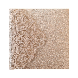 Close-up of laser-cut rose gold glitter lace wedding invitation with floral patterns