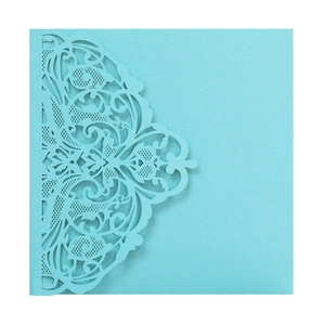 Macro shot of laser-cut lace pattern on light blue pearlescent paper wedding invitation