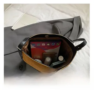 Top view of spacious interior of brown suede bucket bag with tablet and cosmetics