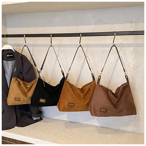 Vue détaillée de quatre sacs hobo en daim minimalistes en coloris kaki, noir et marron